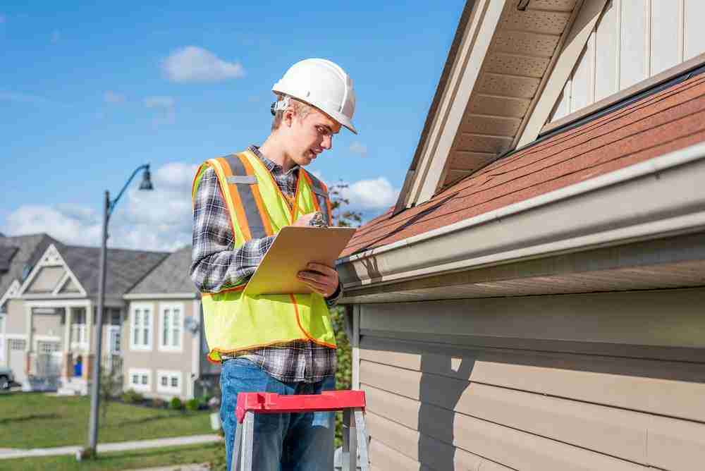 Roof inspector writing on clipboard. Concept for Austin roof inspection taking place.